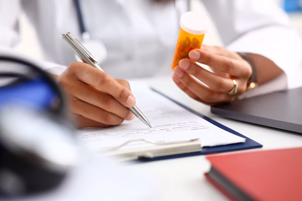 A doctor writing a prescription for pills.