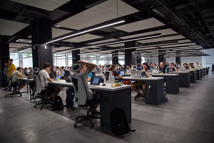 A modern office filled with employees working at computers.